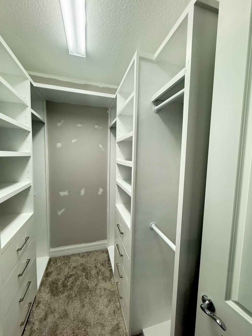 Walk-in closet with shelves and drawers on both sides