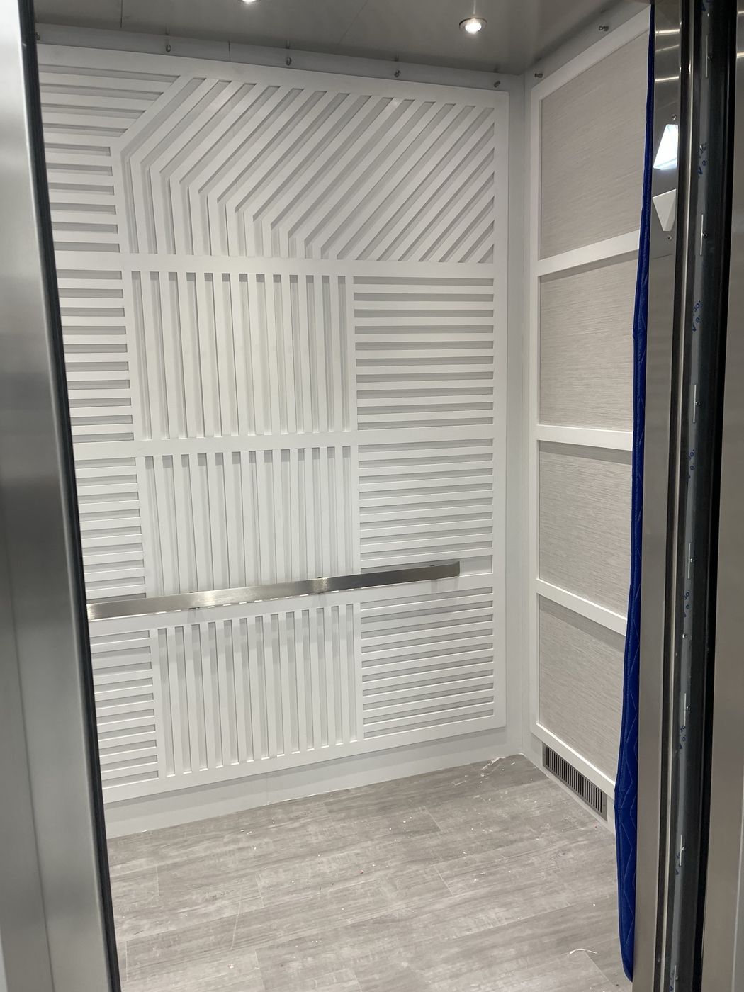 White slatted feature wall inside an elevator cab